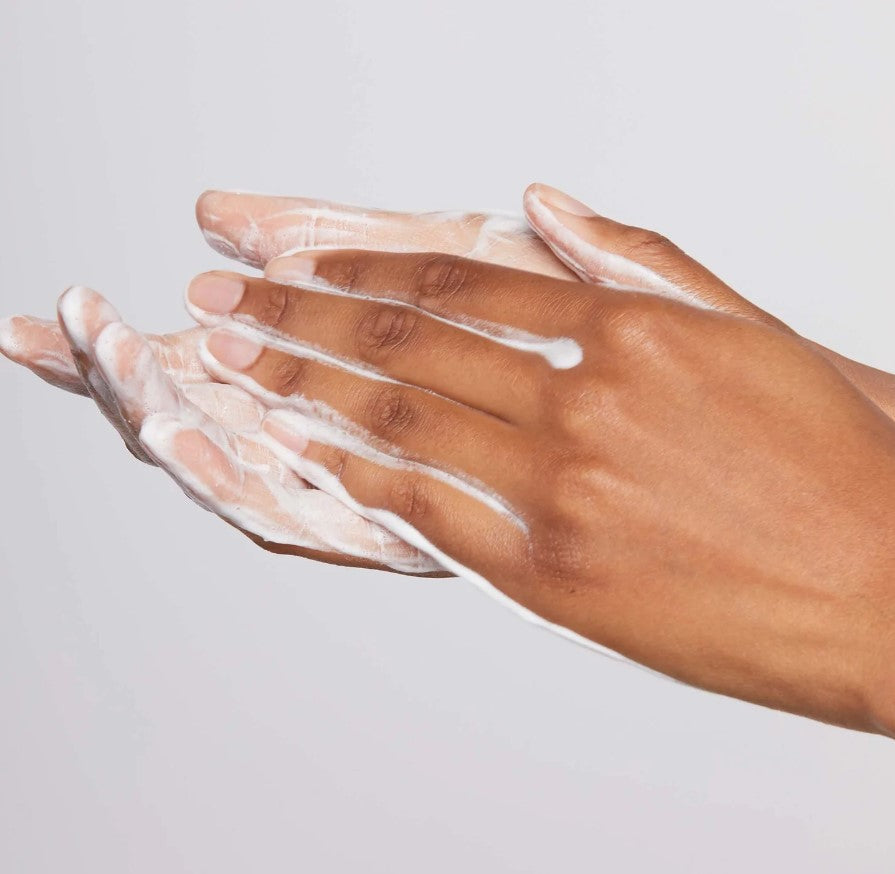 Dermalogica Daily Microfoliant skummer opp mellom hender